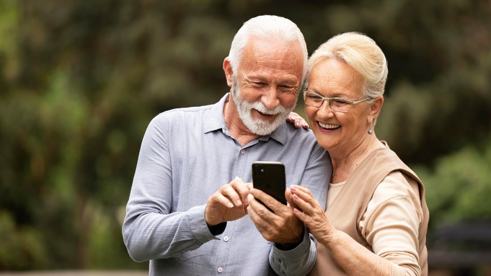 زن و مردی سالمند در حال تماس تصویری از گوشی موبایل