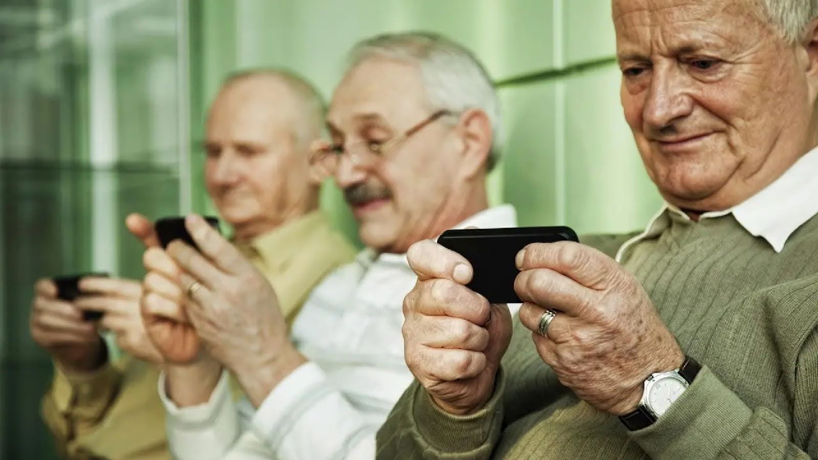 سه نفر از سالمندان در کنار هم در حال استفاده از تلفن همراه